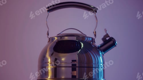 Preview: Silver stainless steel kettle on pink wall background. Action. Close up of new electric kettle