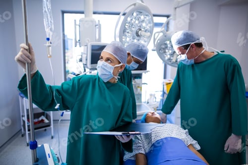 Preview: Female surgeons adjusting iv drip in operation theater