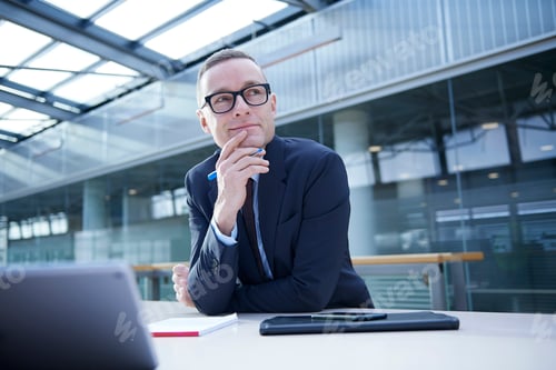 Preview: Businessman thinking at office desk