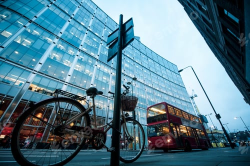 Preview: Bicycle and bus on road near modern building with glass facade