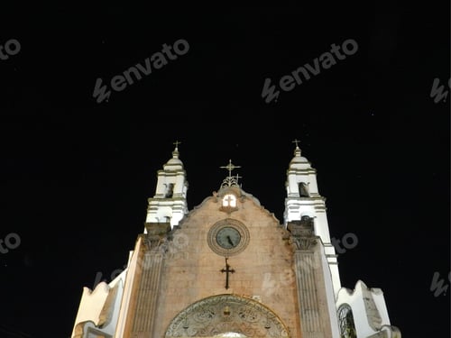 Preview: Clock-adorned church with three towers at night