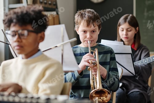 Preview: Boy Playing Trumpet In Orchestra At School