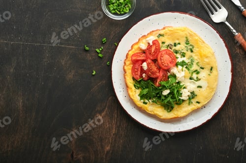 Aperçu: Rustic omelette or frittatas with green onions, cheese mozzarella, green arugula and tomatoes on old