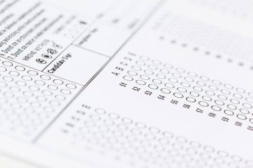 Preview: Test answer sheet showing multiple choice questions and response bubbles in a classroom setting