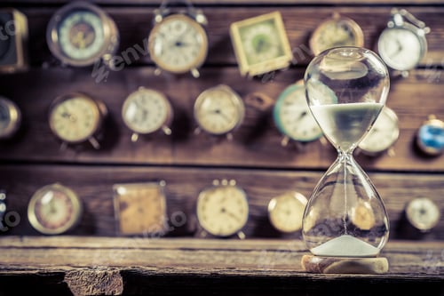 Preview: Old hourglass on the background of clocks