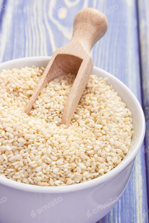 Preview: Sesame seeds with wooden scoop in white bowl