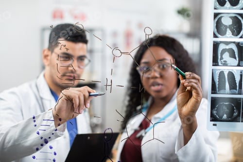 Preview: two multiracial scientists doctors, writing on the wall and looking at chemical formulas