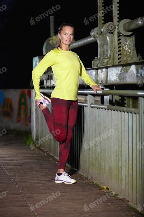 Preview: Young woman stretching before a night run