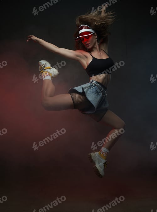 Preview: Female dancer with red cap jumping in dark smoke background