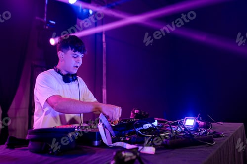 Preview: Young DJ working on mixing board