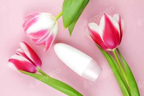 Preview: White bottle with body antiperspirant deodorant roll and pink tulips on a pink background