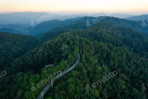 Preview: Aerial view of road and green forest at dusk. Travel and transportation with nature conservation.