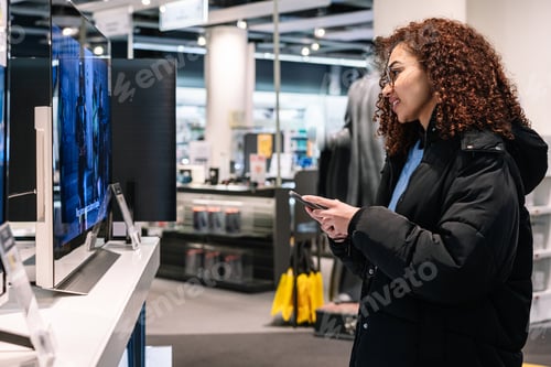 Preview: Black woman looking at TV screen in shop