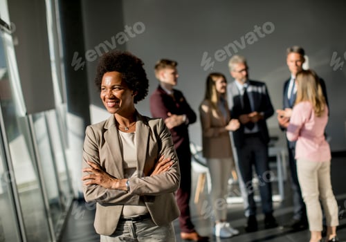 Preview: Professional black woman standing in office with folded arms