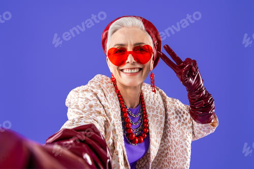 Preview: Happy and funny senior old woman on colorful background