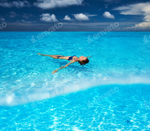 Preview: Woman In Bikini Lying On Water At Tropical Beach