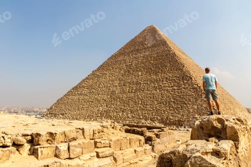 Preview: Man from behind standing on a rock looking at the great pyramid of giza in egypt, tourist, travel