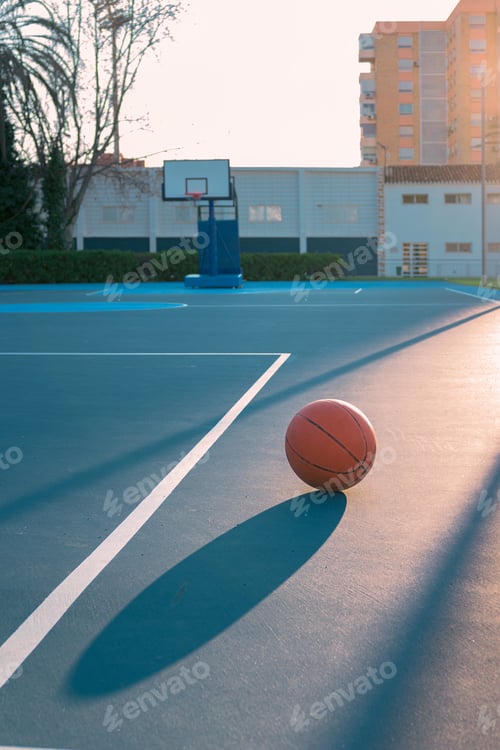 Preview: Detail of a ball on a basketball court at sunset