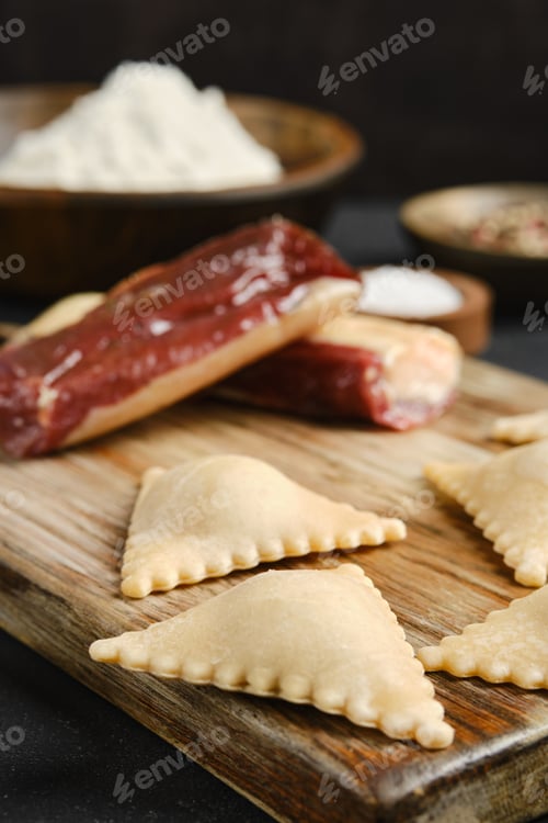 Preview: Homemade dough filled with savory ingredients ready for cooking with spices and flour in background
