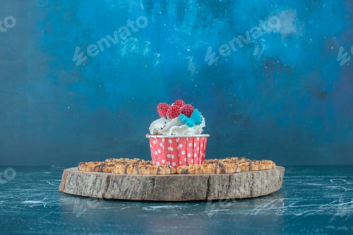 Preview: Cupcake and cookies on a wooden board on blue background
