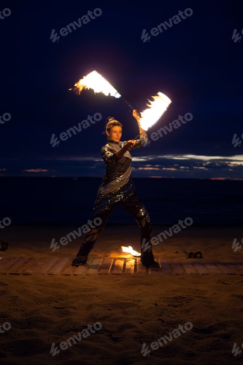 Preview: A girl lights a sparkler on the beach at dusk.