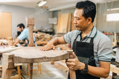 Preview: Carpenter working with wooden plank in workshop. making a furniture from wood