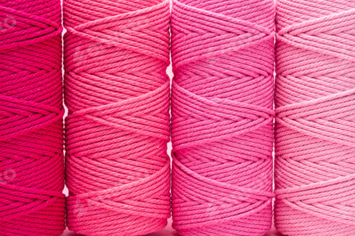 Preview: Close-up of various shades of pink macrame cord spools.
