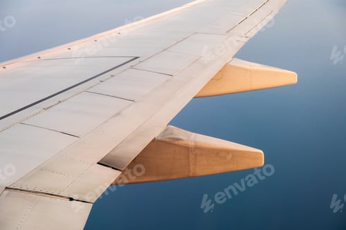 Preview: View from airplane on the aircraft white wing flying over ocean landscape in sunny morning