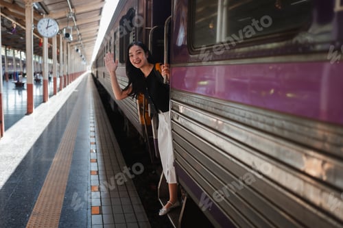 Preview: Woman waving goodbye from departing train at station