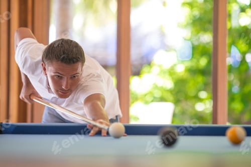 Preview: Young man playing billiards on summer vacation