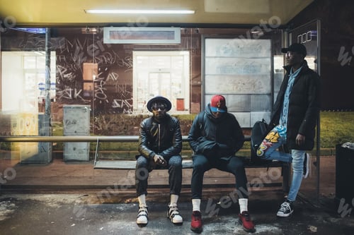 Preview: three young african men waiting on the busstop