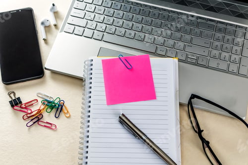 Preview: Closeup of a table with notebook, note pads, laptop and office supplies. Online learning concept