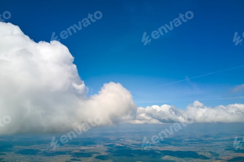 Preview: Aerial view from airplane window at high altitude of earth covered with puffy cumulus clouds forming