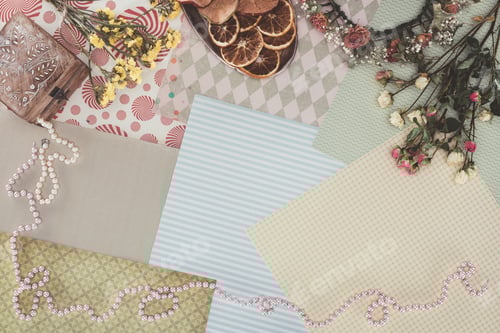 Preview: top view of jewelry box, necklaces, flowers and dry fruits over pack paper background