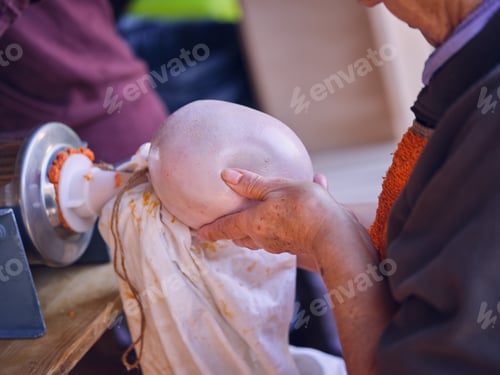 Preview: Elderly person stuffing bowl with meat