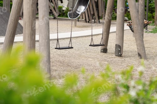 Preview: Two children's swings in the summer park.
