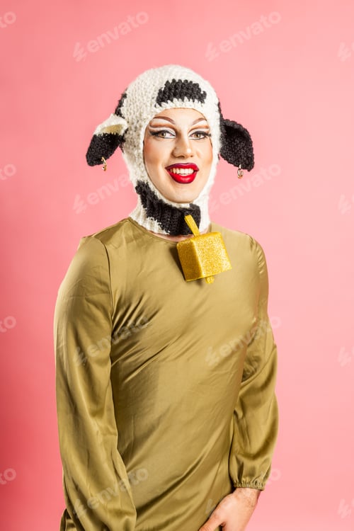 Preview: Smiling Drag Queen Showcases Crochet Cow Costume in Colorful Studio Setting