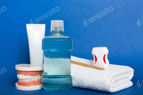 Preview: Mouthwash and other oral hygiene products on colored table top view with copy space