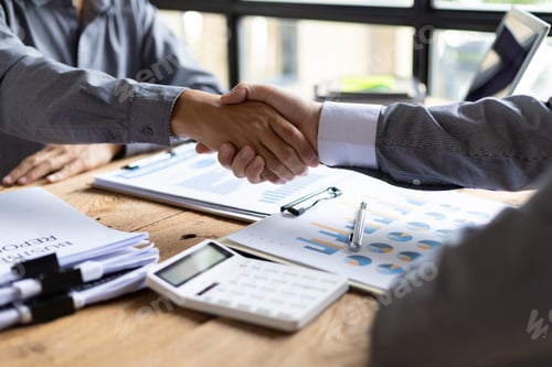Preview: Handshake. Businessman on desk shaking hands with accountant or financial advisor in office.