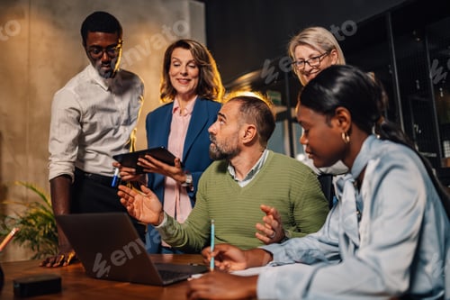 Preview: Multicultural businesspeople working together on a laptop at office.