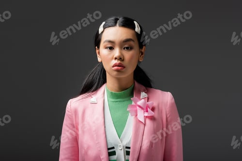 Preview: Asian woman with barrettes looking at camera isolated on grey