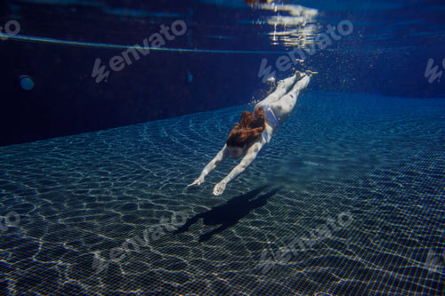 Preview: Businesswoman diving into swimming pool in white bikini: reaching for success