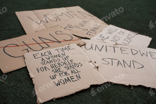 Preview: Messages for the people. Group of banners with different feminist quotes lying on the ground