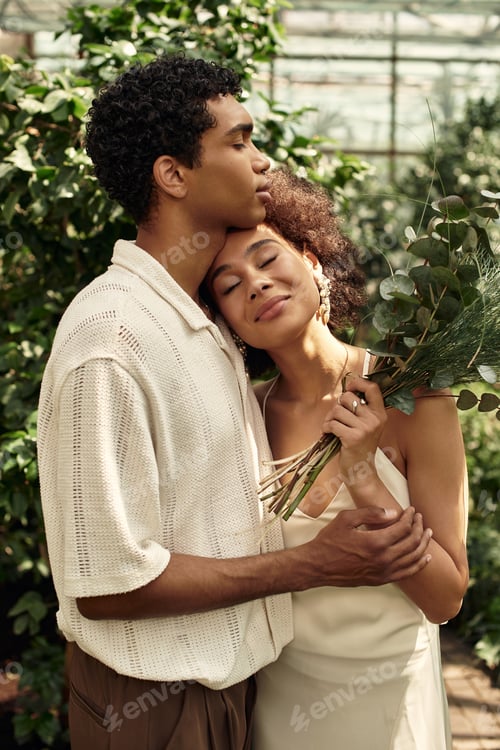 Preview: Young couple shares a tender moment in a lush greenhouse surrounded by vibrant greenery