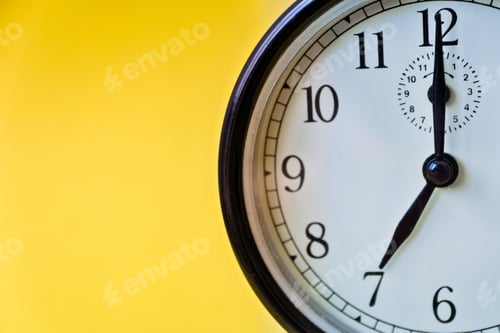Preview: Shot of vintage retro analog clock on yellow background showing seven o clock