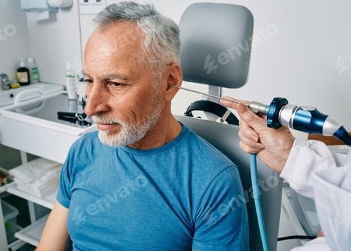 Preview: ENT doctor examining senior man's ear using endoscope at otolaryngology clinic. Ear endoscopy