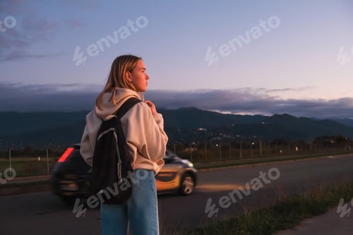 Preview: Woman with Backpack Gazing at Scenic Mountain View