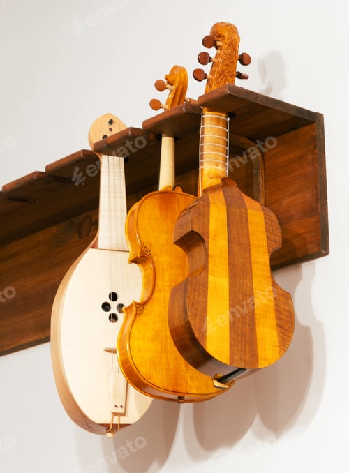 Preview: Various handmade string instruments hanging on display stand