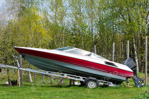 Preview: A motorboat on a trailer on a green meadow