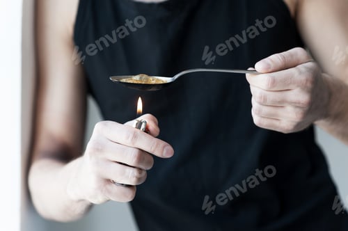 Preview: Boiling heroin. Close-up of man boiling heroin in spoon